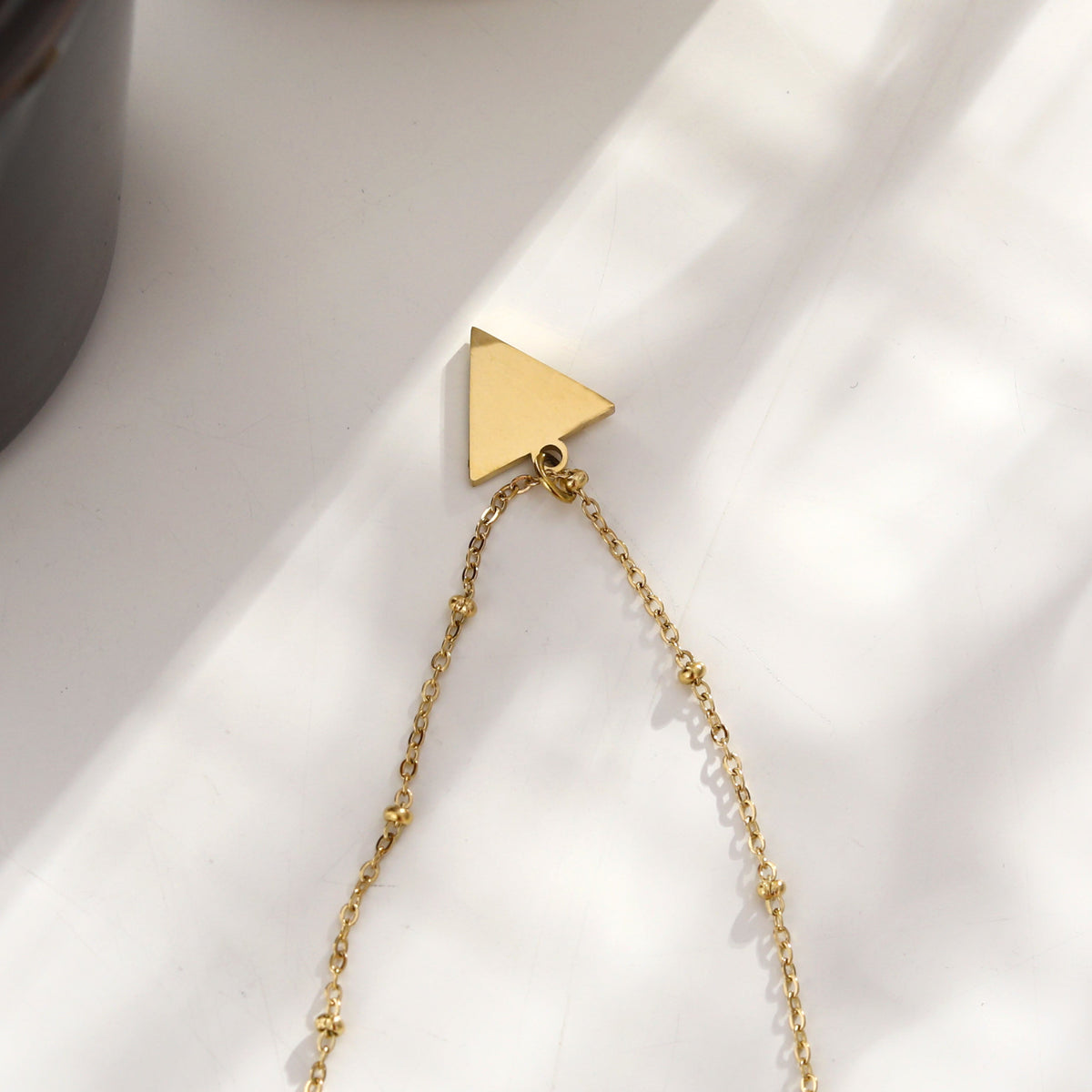 Collier chaîne perlée URIKA avec pendentif triangle pavé de zircons dorés