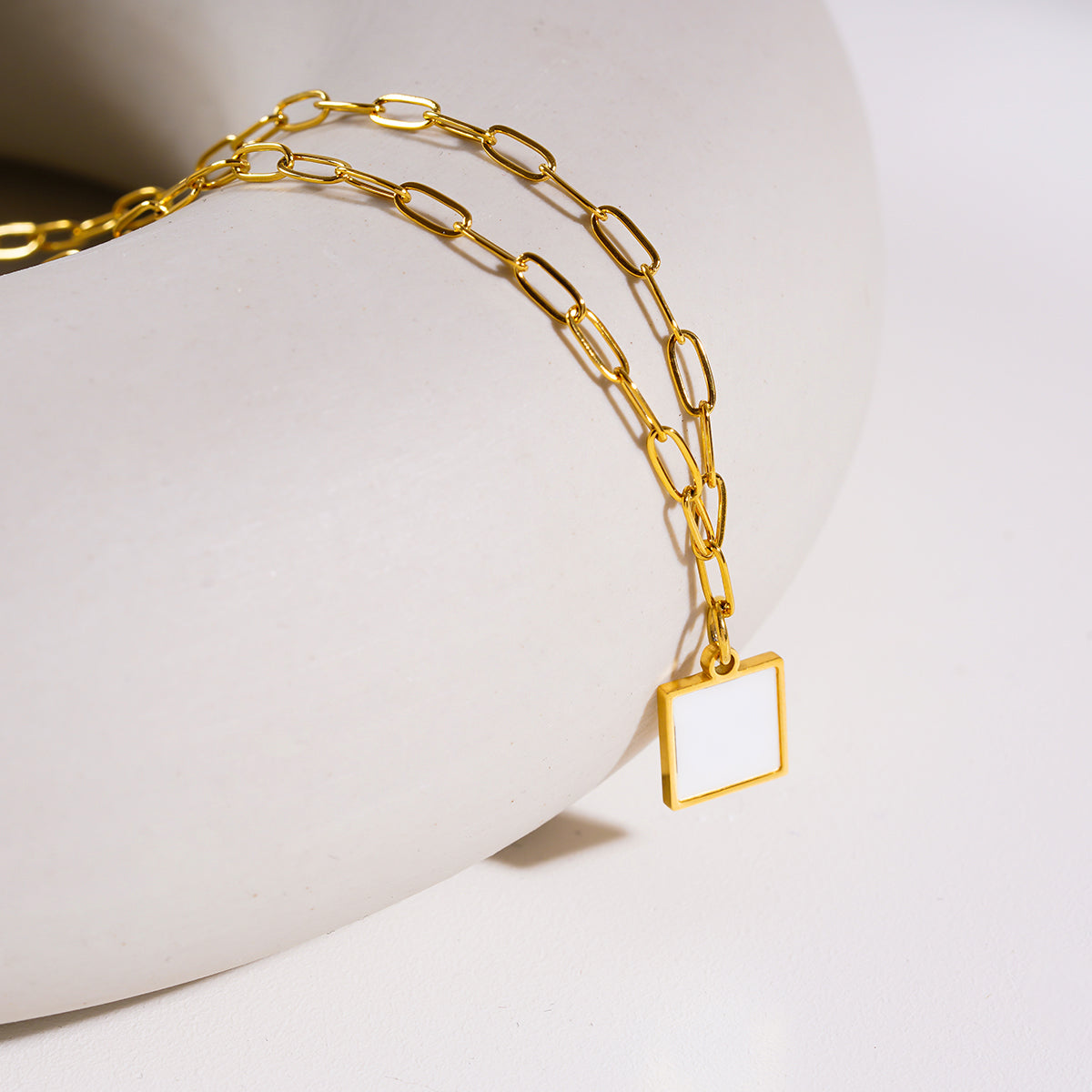 Style ANNABELLA : Pendentif carré minimaliste en métal et coquillage sur une chaîne trombone.