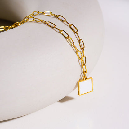 Style ANNABELLA : Pendentif carré minimaliste en métal et coquillage sur une chaîne trombone.