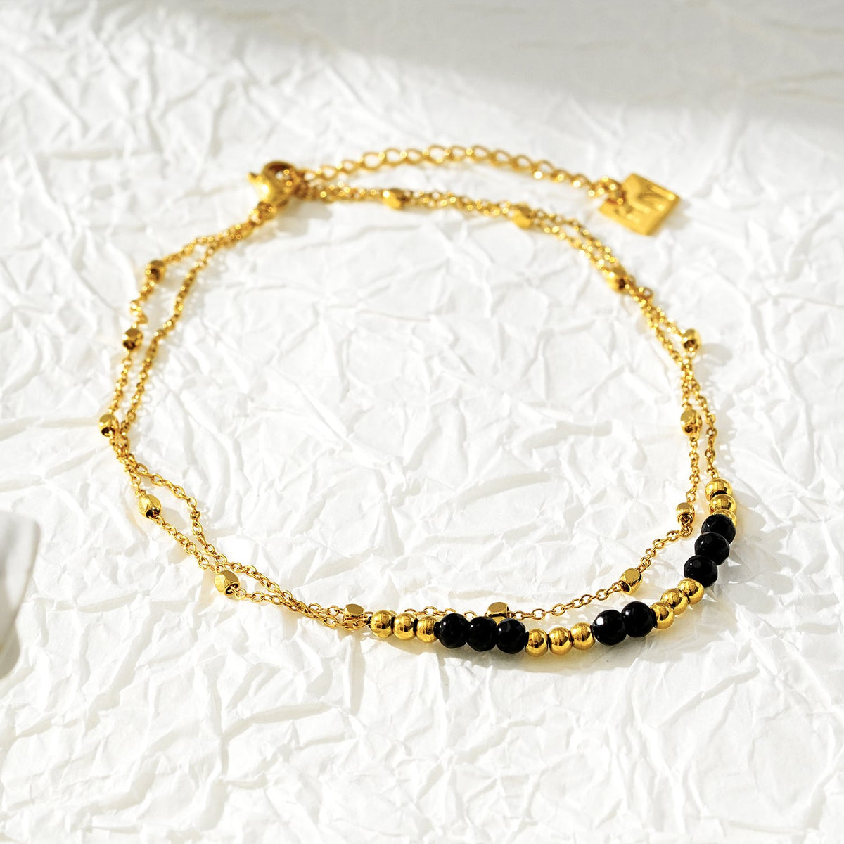 HILDA LG : Bracelet de cheville perles carrées et perles rondes deux-en-un noir et or.