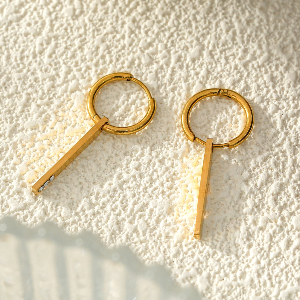 Style MAYLA : Créoles dorées au charme minimaliste, rehaussées d'un trio de zircons.