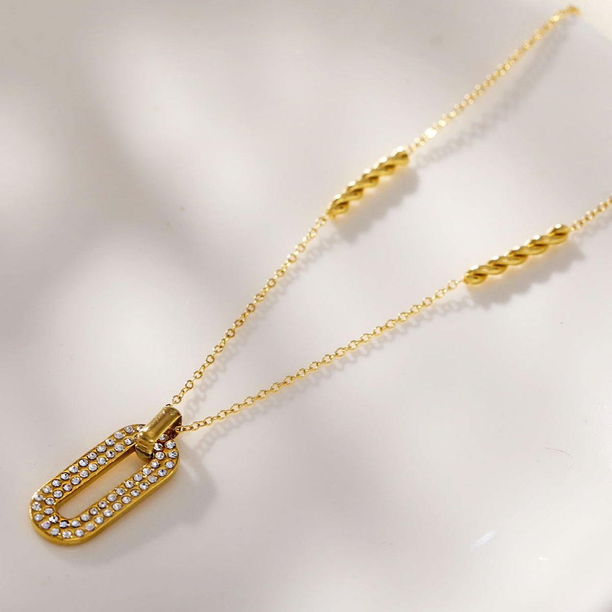 ASKIRA : Chaîne combinée torsadée avec un pendentif ovale orné de zircone