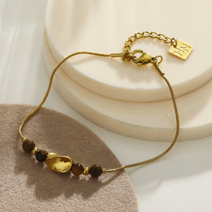 Bracelet RIO texturé effet serpent avec breloques dorées et œil de tigre